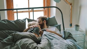 Paar kuschelt im Bett