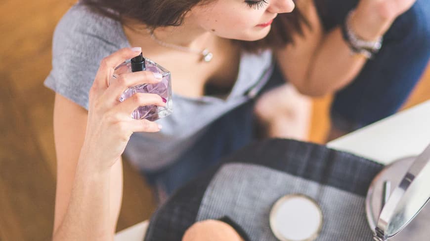 Frau mit Parfum in der Hand