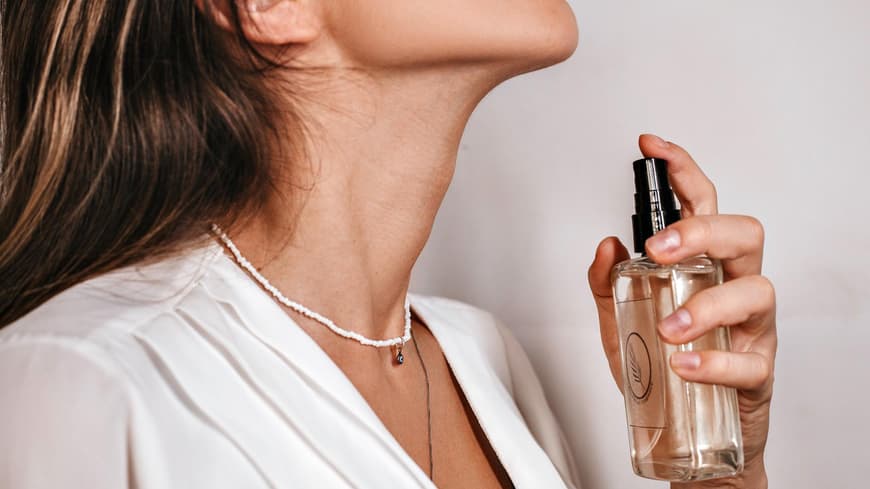 Frau trägt Parfum auf
