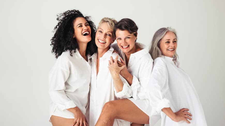 Vier ältere Frauen lachen zusammen.