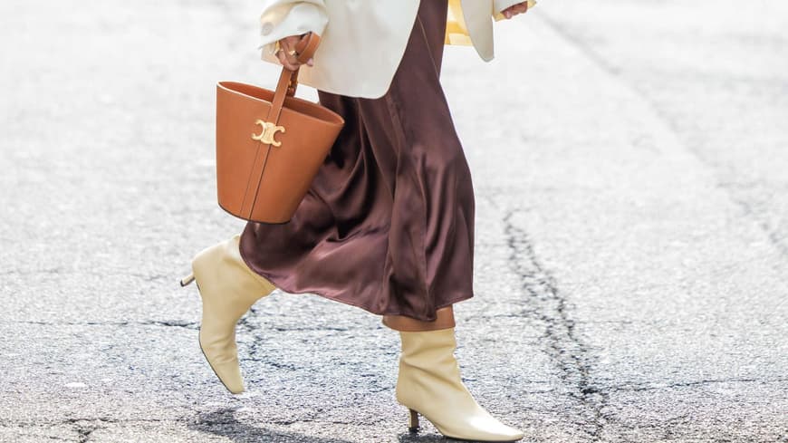 Frau mit braunem Satinkleid und weißem Blazer