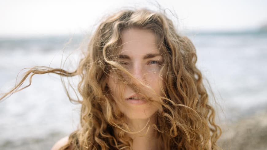 Frau mit Locken und fliegenden Haaren