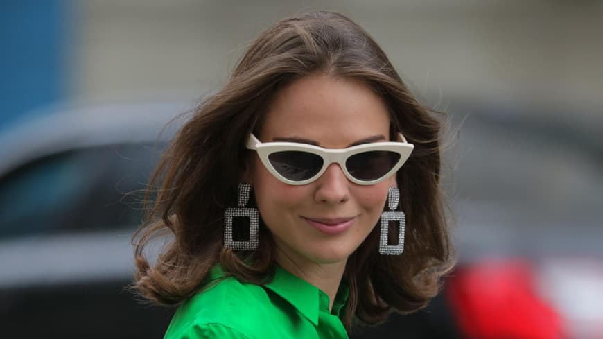 Frau mit Sonnenbrille und Statement-Ohrringen