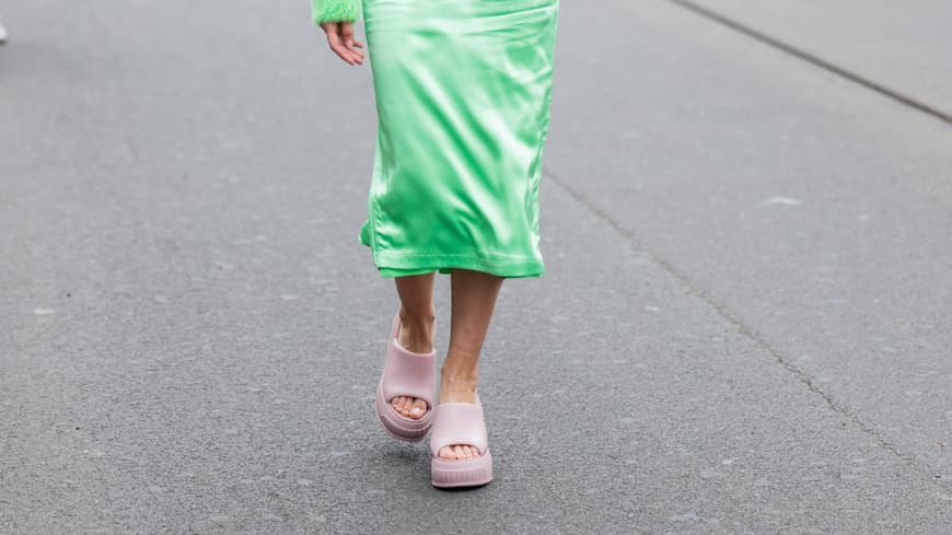 Frau mit grünem Rock und Pullover und rosa Sandalen