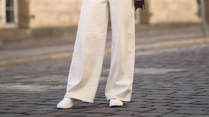 Frau trägt beige Hose und Sneaker