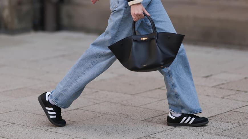 Frau trägt Adidas Sneaker und Jeans