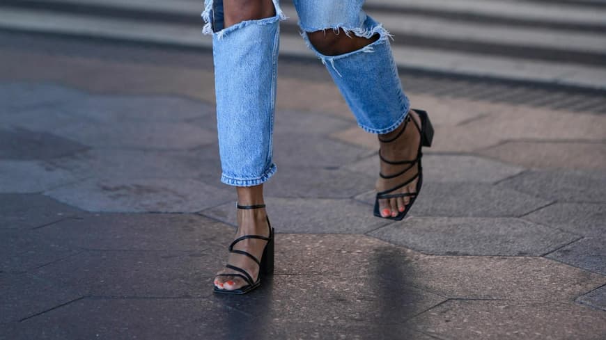 Frau trägt schwarze Sandalen