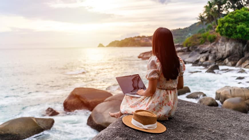 Frau mit Laptop am Strand
