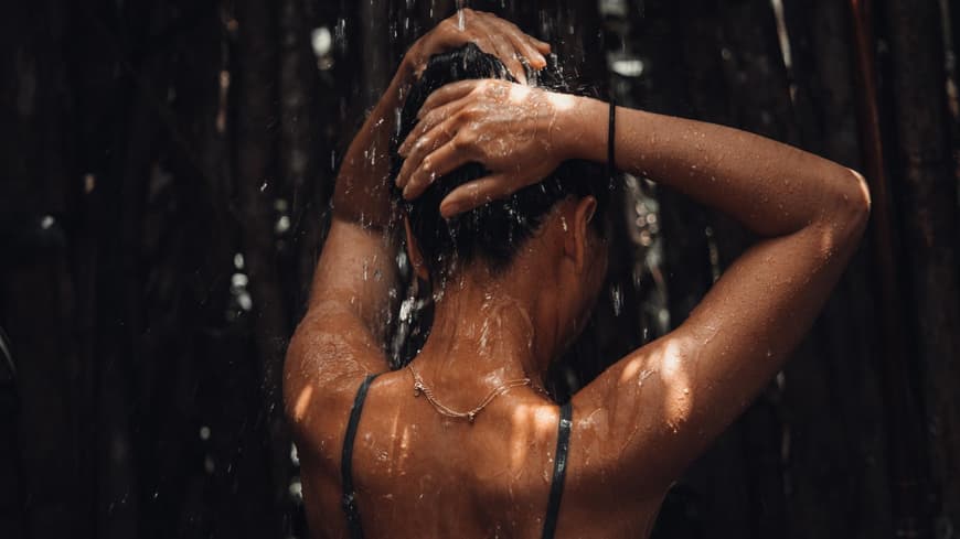 Frau im Bikini unter der Dusche