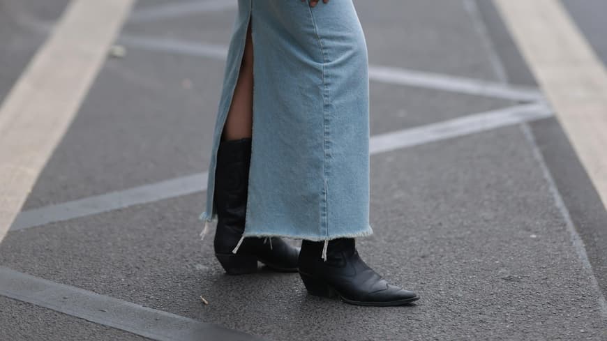 Eine Frau trägt einen Jeansrock und schwarze Stiefeletten
