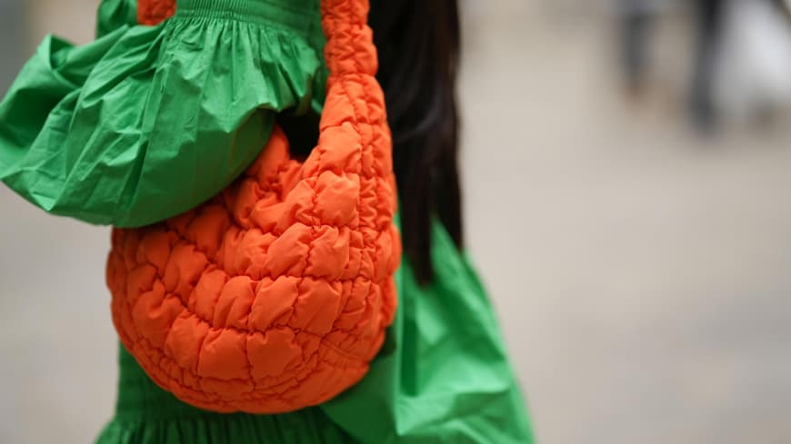 Eine Frau trägt eine große Tasche von COS