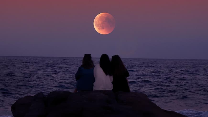 Frauen sitzen am Meer