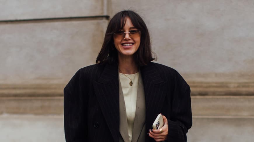 Frau auf Copenhagen Fashion Week trägt Haare mit Pony und Fashion Look mit Blazer