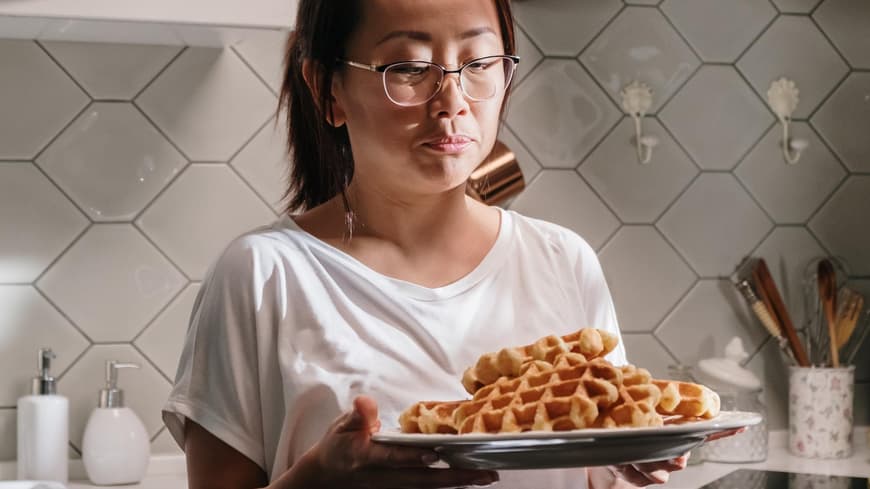 Frau mit einem Teller gebackener Waffeln