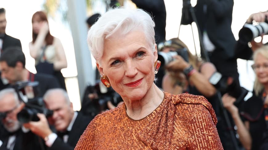 Maye Musk auf den Cammes Filmfestspielen mit grau weißen Haaren und bronzefarbenen Kleid kurze Haare