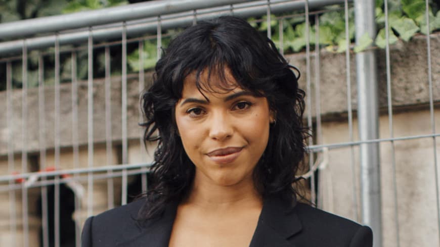 Paris Streetstyle Frau trägt angesagten Look und Locken im Haar plus pony