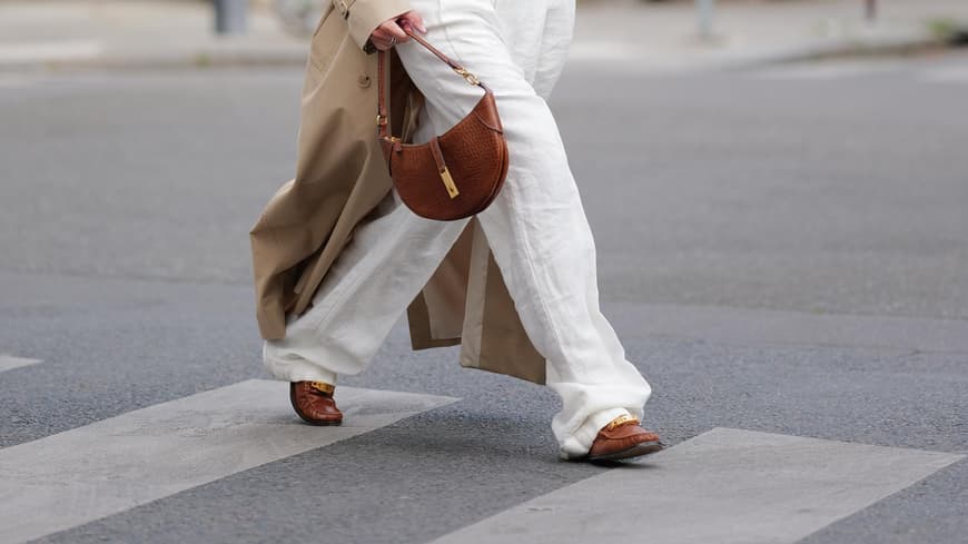 Eine Frau trägt einen Trenchcoat und Loafer