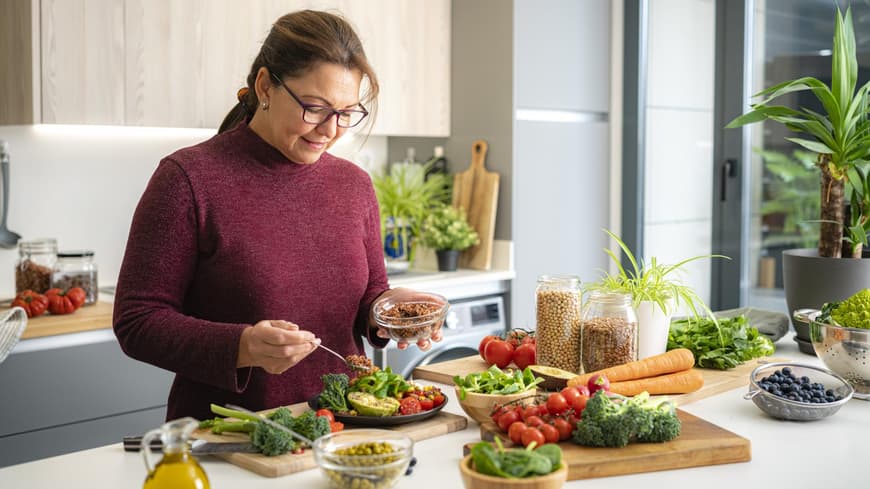 Frau bereitet in der Küche einen Salat zu