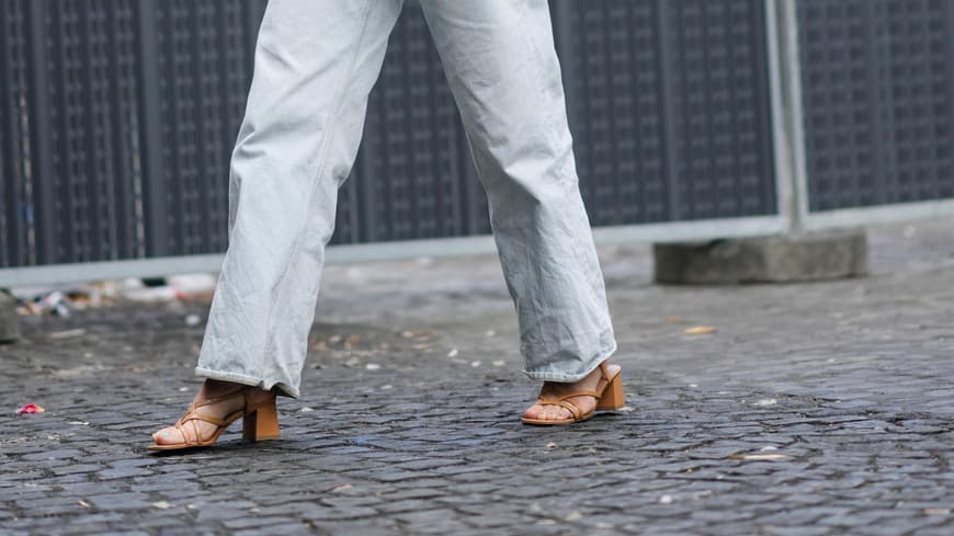 Frau mit braunen Sandaletten zu Jeans