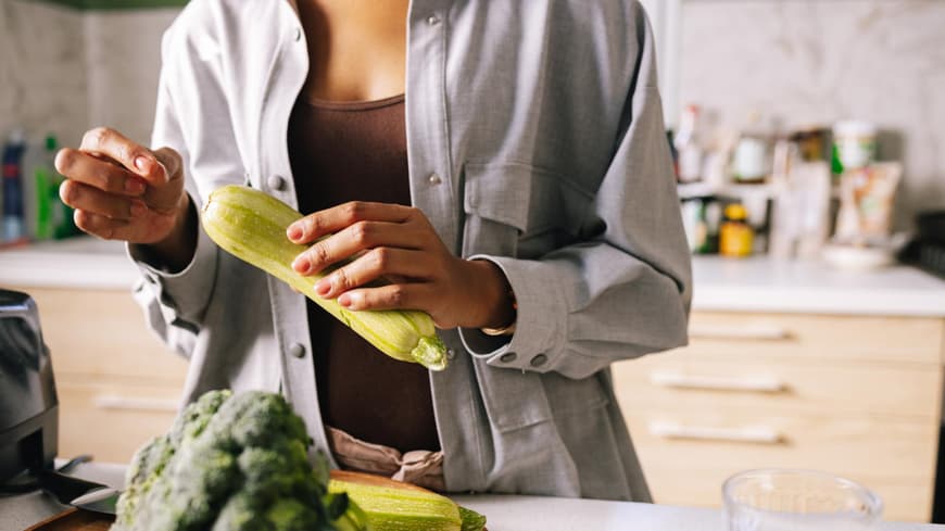 Frau hält Zucchini in der Hand