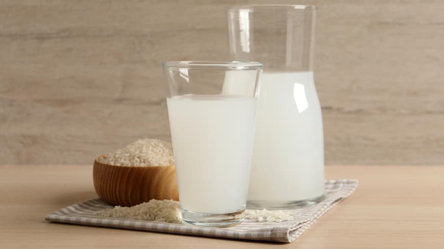 Ein Glas Reiswasser und eine Karaffe stehen auf einem Tisch