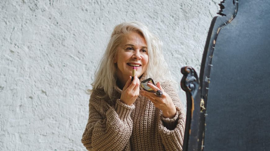 Frau trägt Lippenstift auf