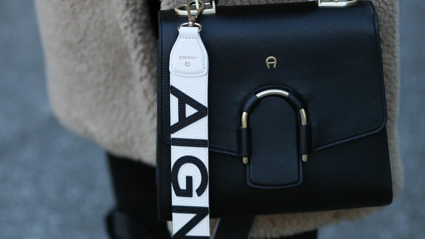 Frau trägt schwarze tasche von Aigner