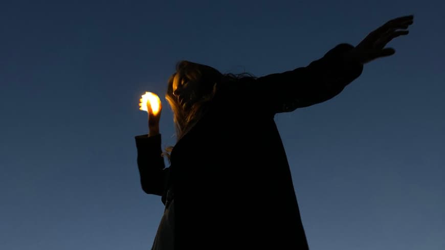 Frau hält eine kleine Lichtkugel in der Hand