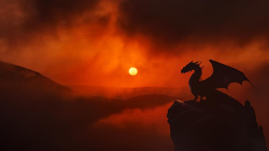 Drache auf einem Fels während eines Sonnenuntergangs