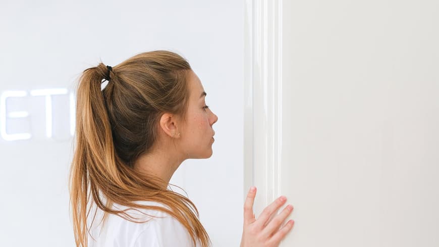 Frau schaut in Kühlschrank