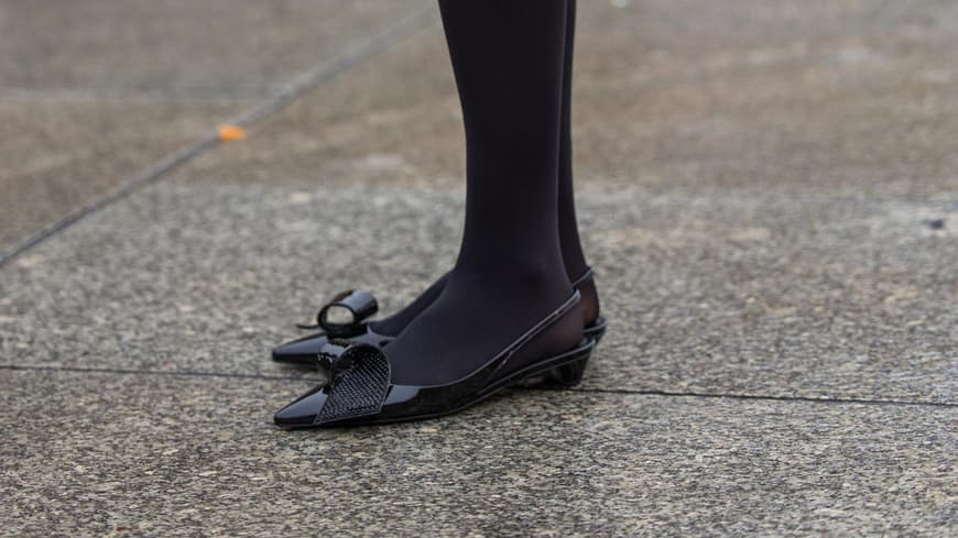 Lea Naumann trägt schwarze Kitten Heels und schwarze Prada Tasche und Strumpfhose Streetstyle