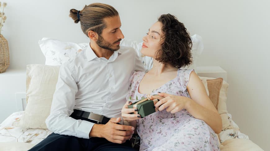 Mann und Frau sitzen auf dem Bett und gucken sich an