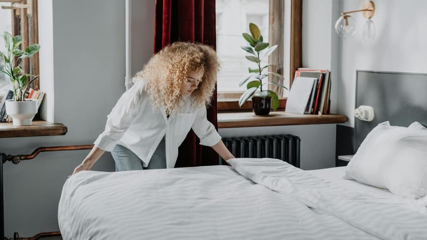 Frau macht das Bett