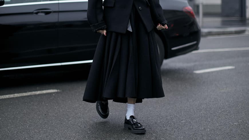 Frau trägt auf Mailand Fashion Week schwarze Prada Loafer