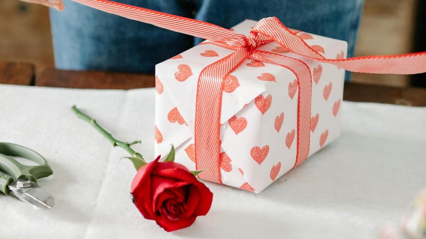 Frau packt ein Geschenk mit Herzen ein
