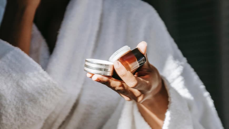 Frau hält Gesichtscreme in der Hand