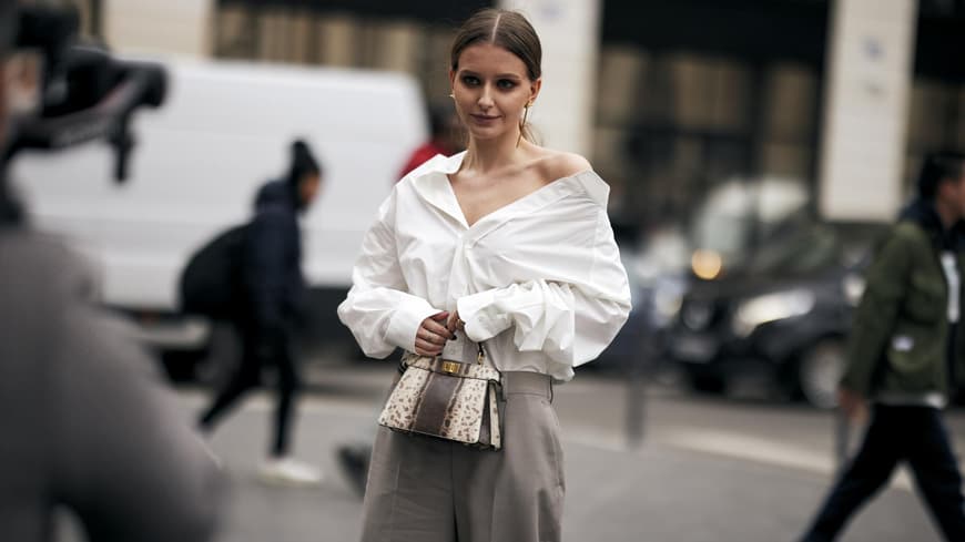 Frau trägt auf Paris Fashion Week weiße Bluse und graue Hose Streetstyle plus Tasche