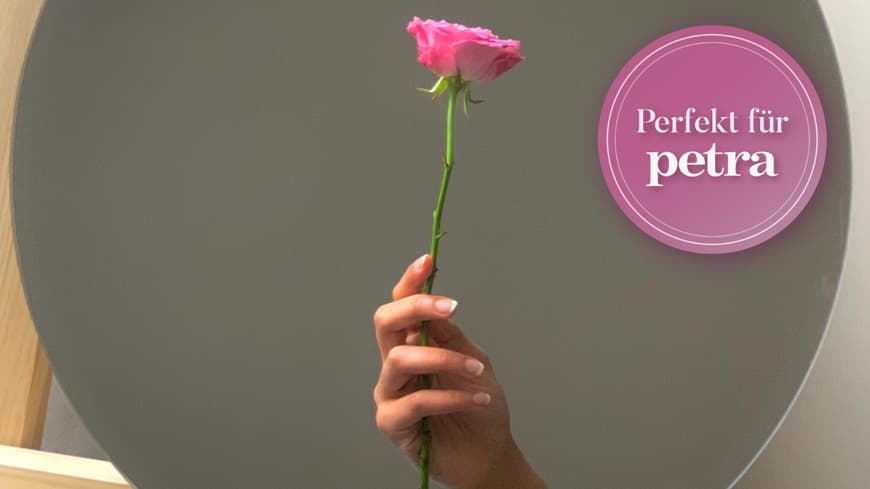 Frau hält Rose in der Hand