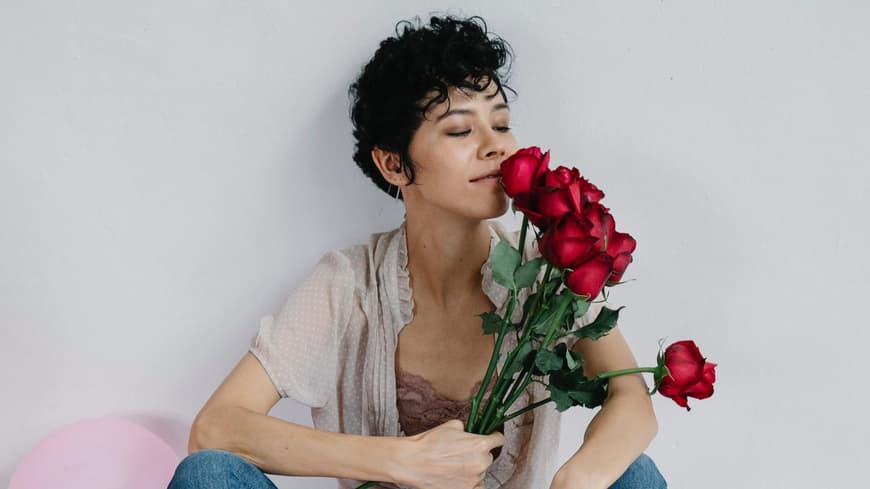Frau hält einen Strauß Rosen in der Hand