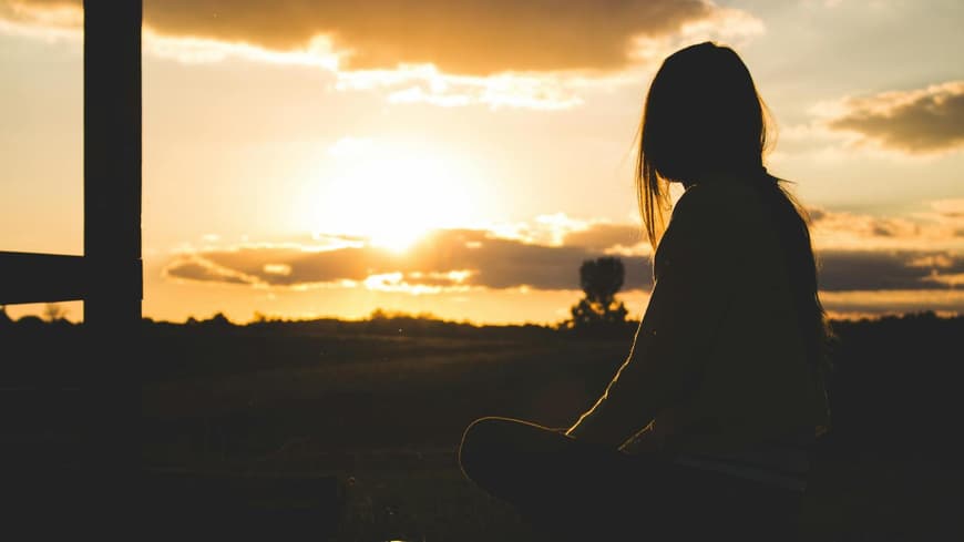 Frau schaut in die Abendsonne