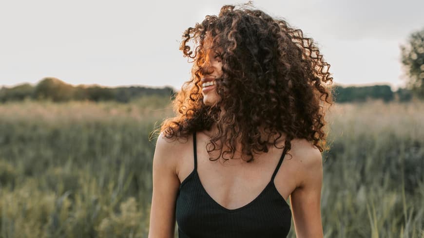 Frau mit Locken in der Natur