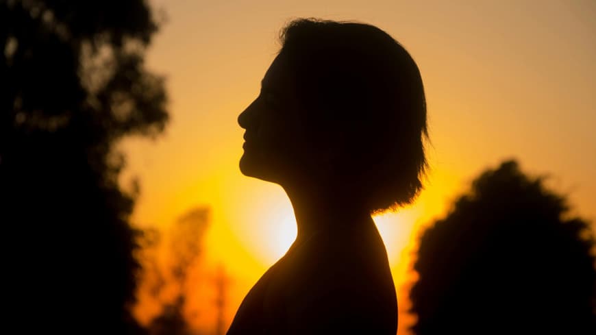 Silhouette einer Frau vor dem Sonnenaufgang 