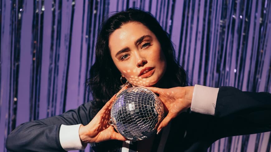 Was anziehen zur 80er Mottoparty: Frau mit Discokugel