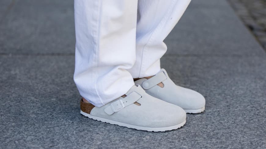 Birkenstock Boston in Grau mit einer weißen Hose kombiniert.
