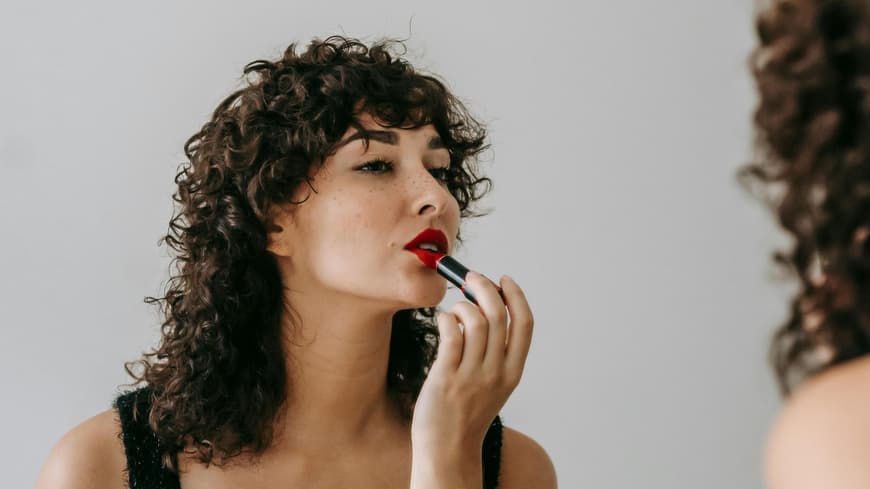 Frau traegt wasserfesten Lippenstift auf