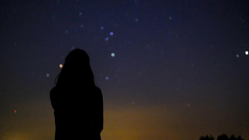 Wochenhoroskop: Frau blickt in den Sternenhimmel