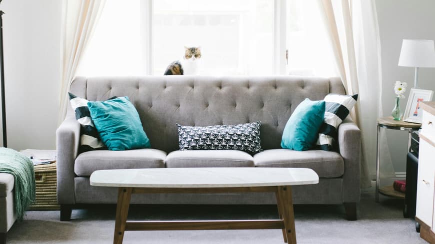 Grauer Sofa mit türkisen Kissen