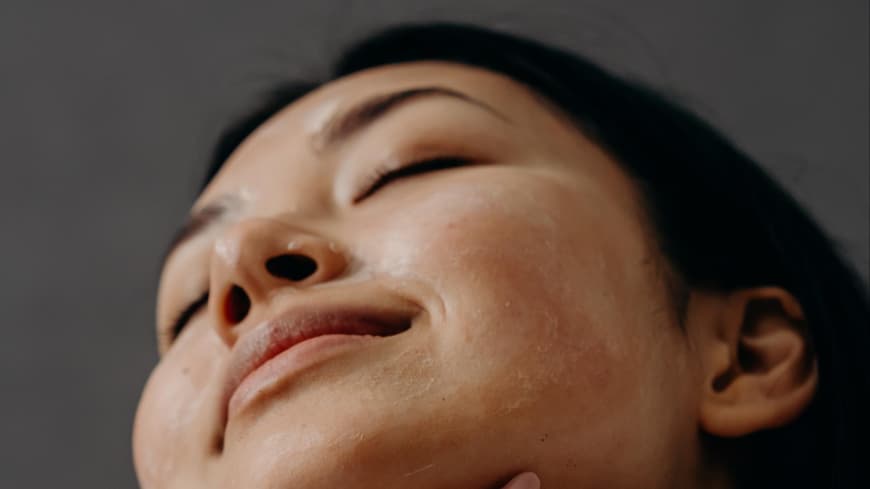 Frau traegt Sonnencreme auf