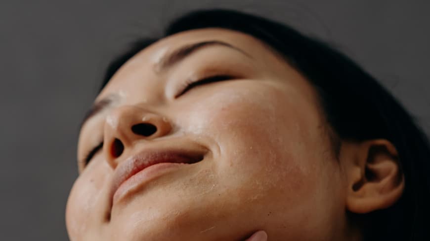 Frau traegt Sonnencreme auf