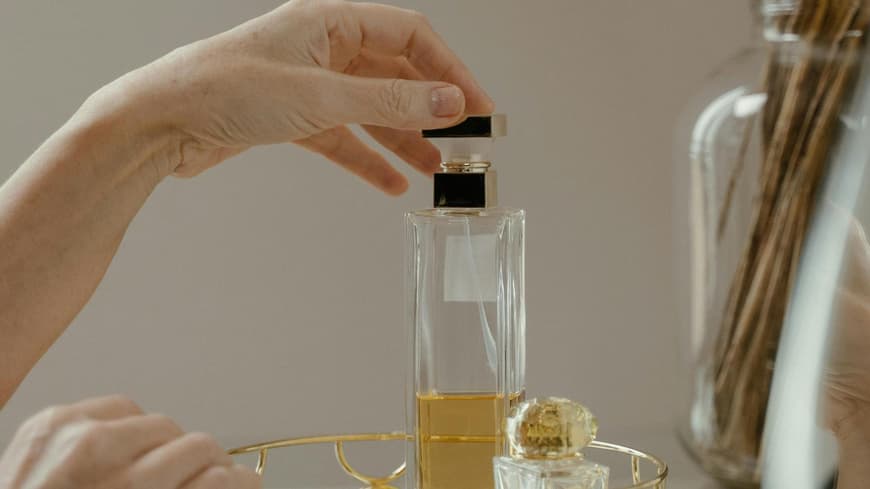 Frau greift nach Parfum